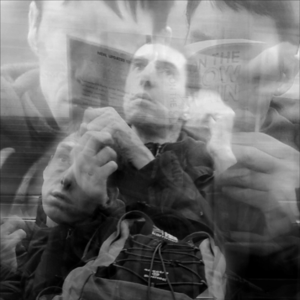 A multiple‑exposure photograph on a subway carriage, showing overlapping images of a person seated with a book, their hands, face, and posture appearing in several offset positions alongside a backpack
